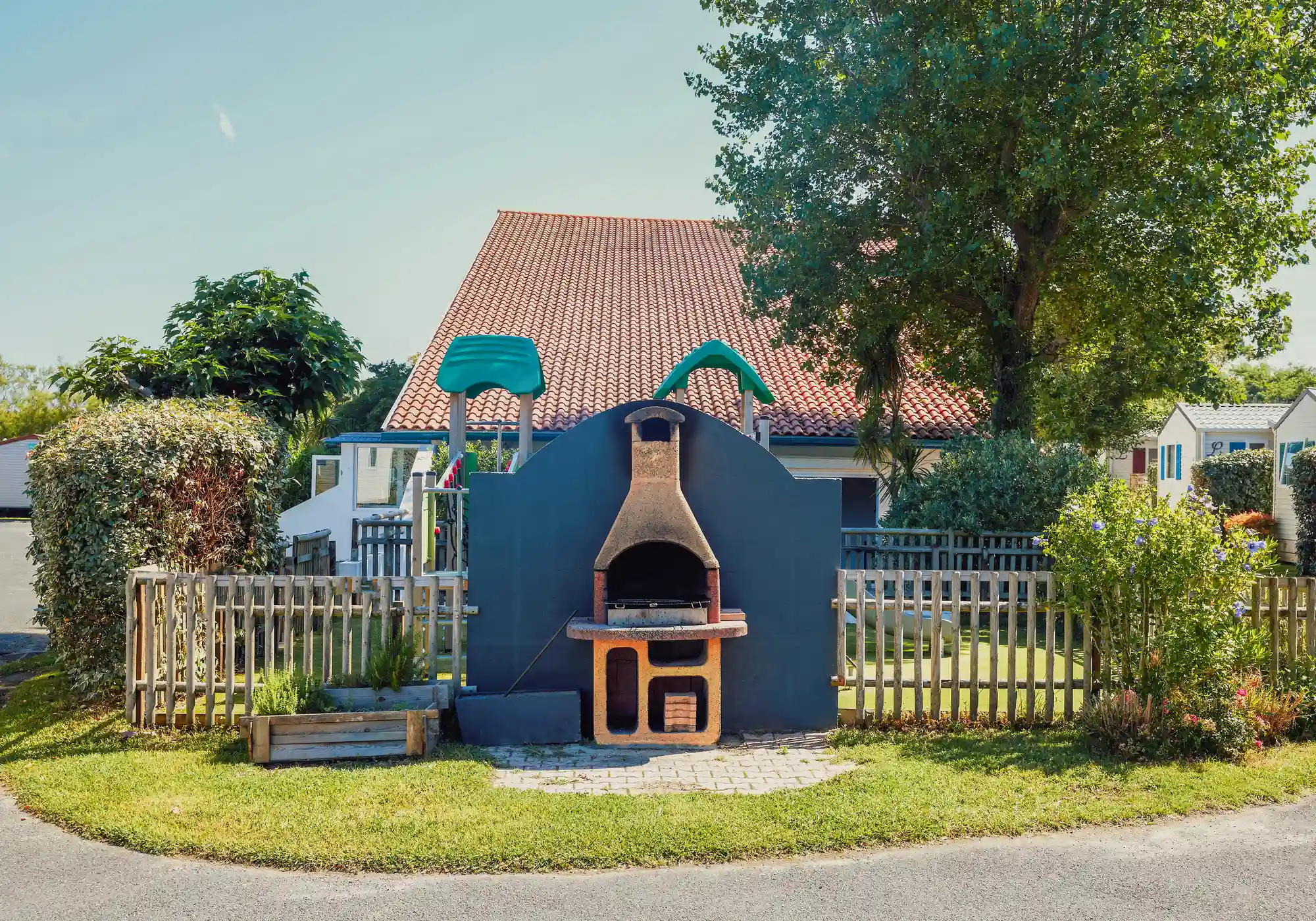 Jardin avec barbecue et clôture en bois