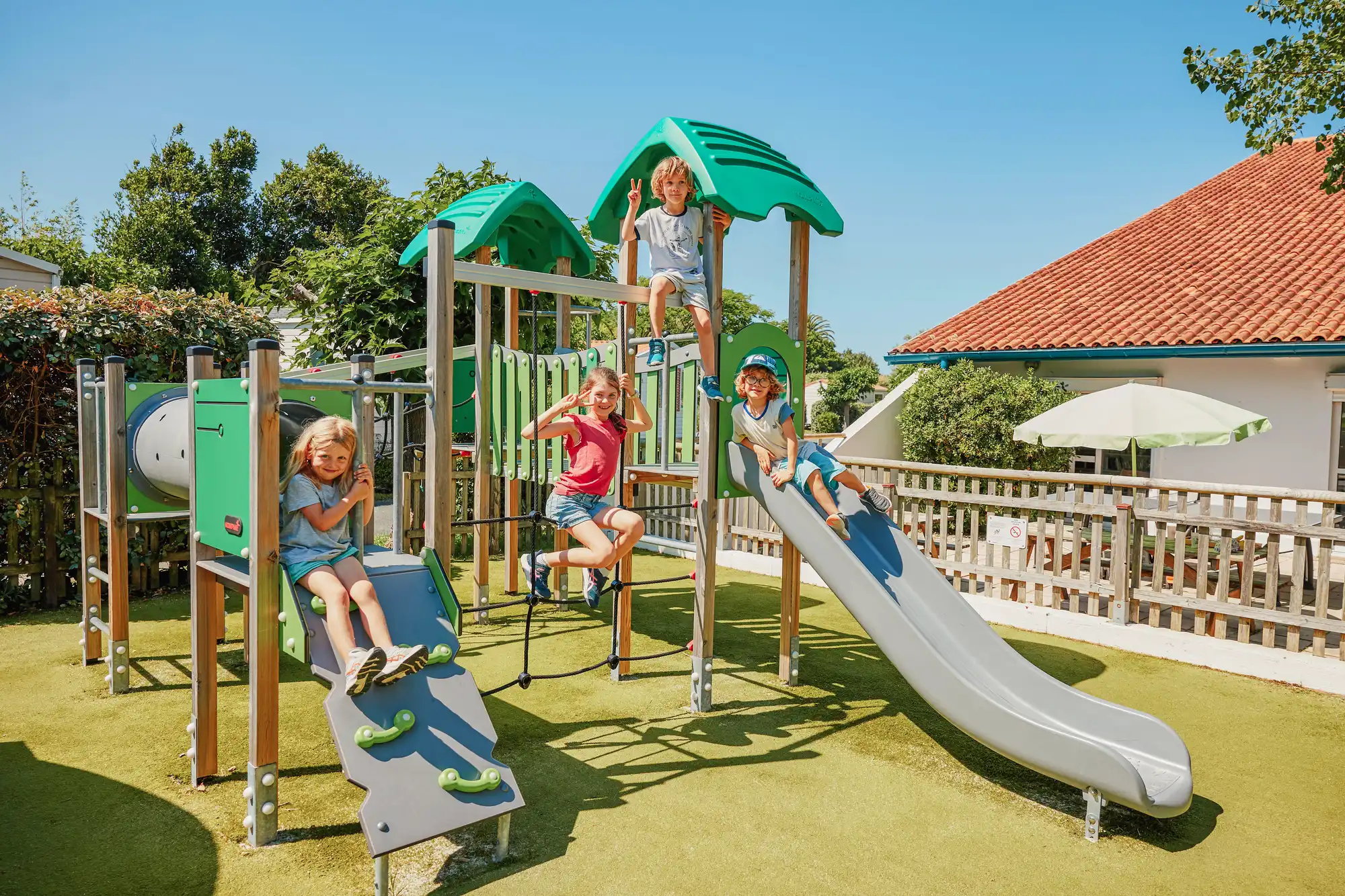 Enfants jouant sur une aire de jeux extérieure.