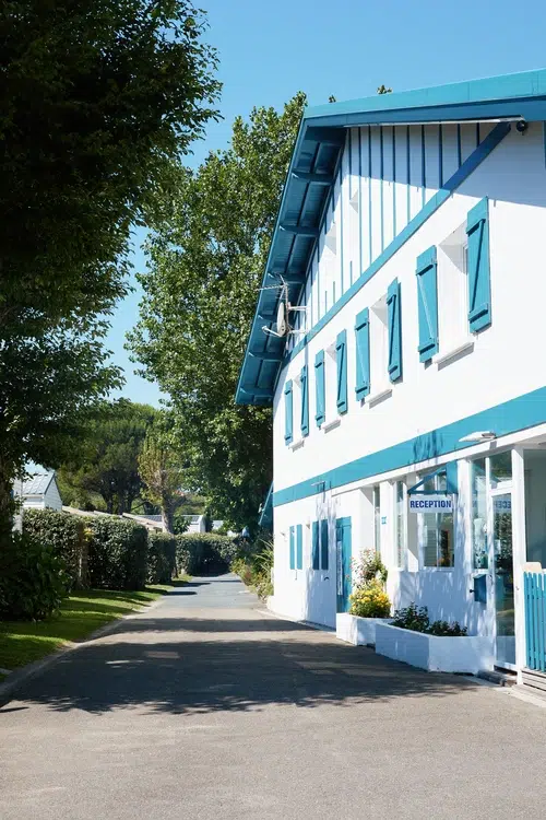 Entrada a un hotel moderno con contraventanas azules.