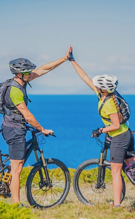 Dos ciclistas se felicitan cerca del mar